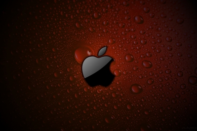 High def wallpaper of Apple logo in gloss black on red wet surface.